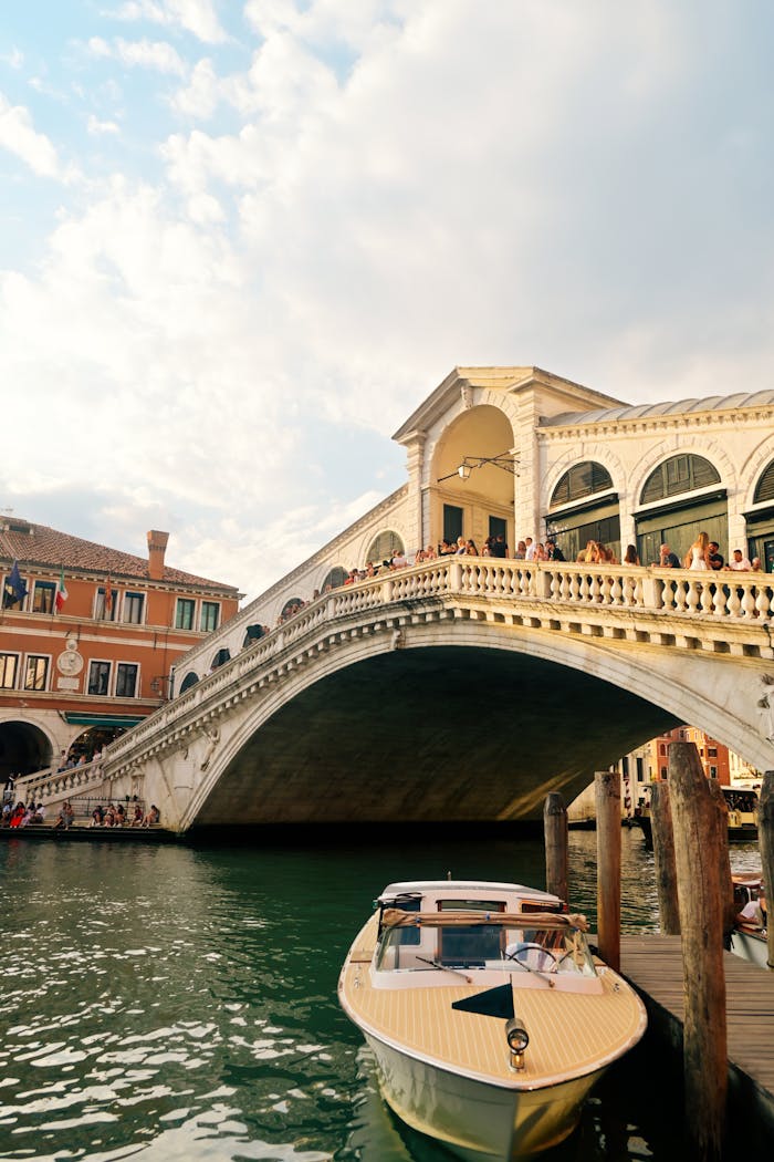 A scenic view of Rialto Bridge with a boat moored below, capturing the essence of Venice.